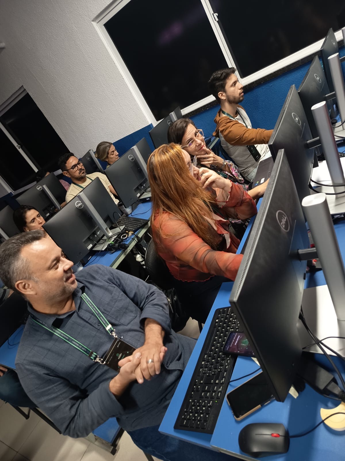 Participantes trabalhando juntos nos computadores durante a imersão